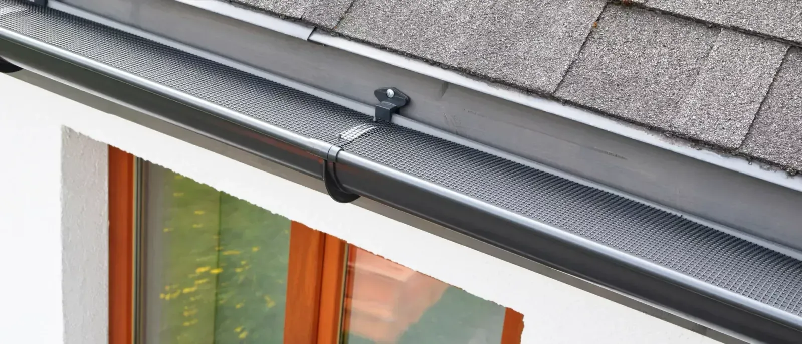 A fine mesh guard fitted the full length of a dark gutter run