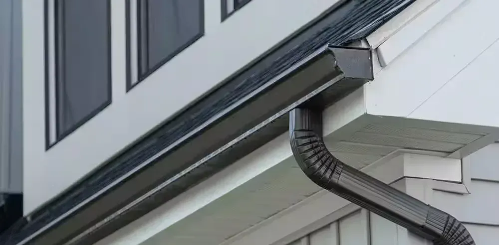 Looking along a gutter run to where the downspout drops from the eave
