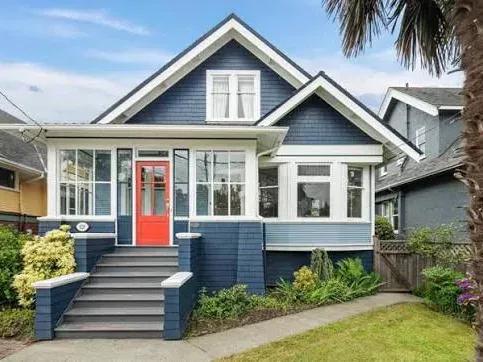 A blue character home in Victoria with a steep gable, dormer and an enclosed front porch